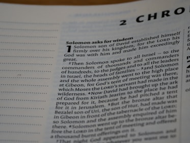 A close-up view of a text from a religious book, focusing on a chapter titled '2 Chronicles'. The passage 'Solomon asks for wisdom' is highlighted, and the text discusses Solomon's establishment over his kingdom and his request for wisdom from God. The page includes numbered sections and is written in a formal, structured format.