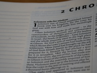 A close-up view of a text from a religious book, focusing on a chapter titled '2 Chronicles'. The passage 'Solomon asks for wisdom' is highlighted, and the text discusses Solomon's establishment over his kingdom and his request for wisdom from God. The page includes numbered sections and is written in a formal, structured format.