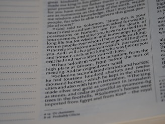 A close-up view of a page from a book displaying printed text. The text appears to be in English and contains paragraphs on the right side. There is a series of numbered verses in a column, likely from a religious or historical text, with some words emphasized in bold.