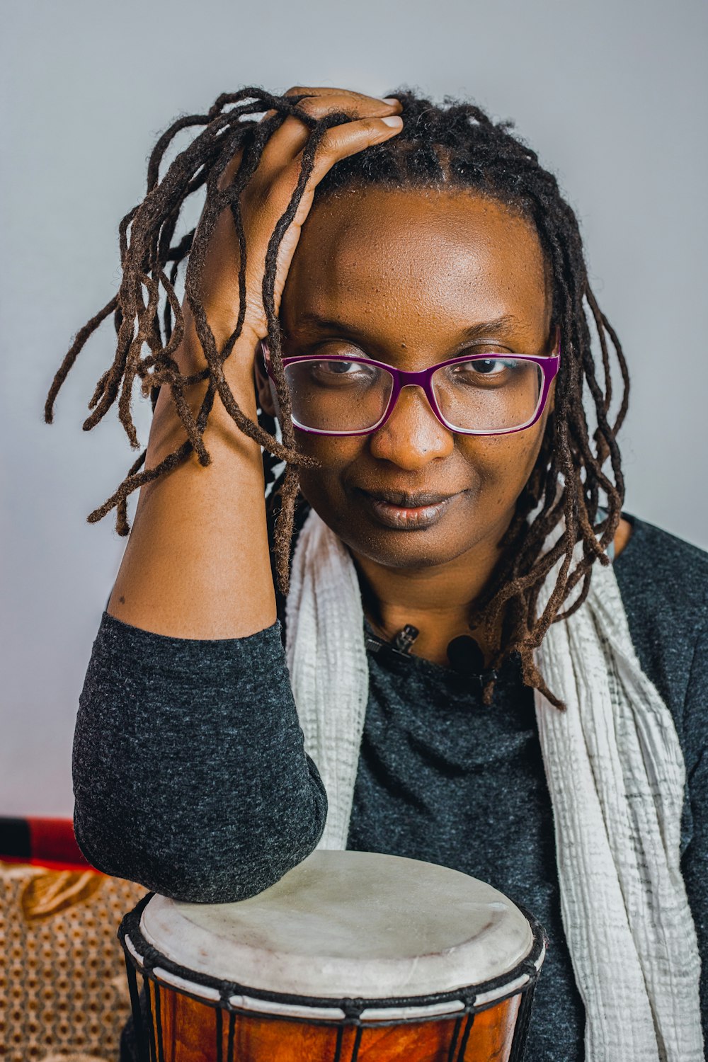 a woman with glasses is holding a drum