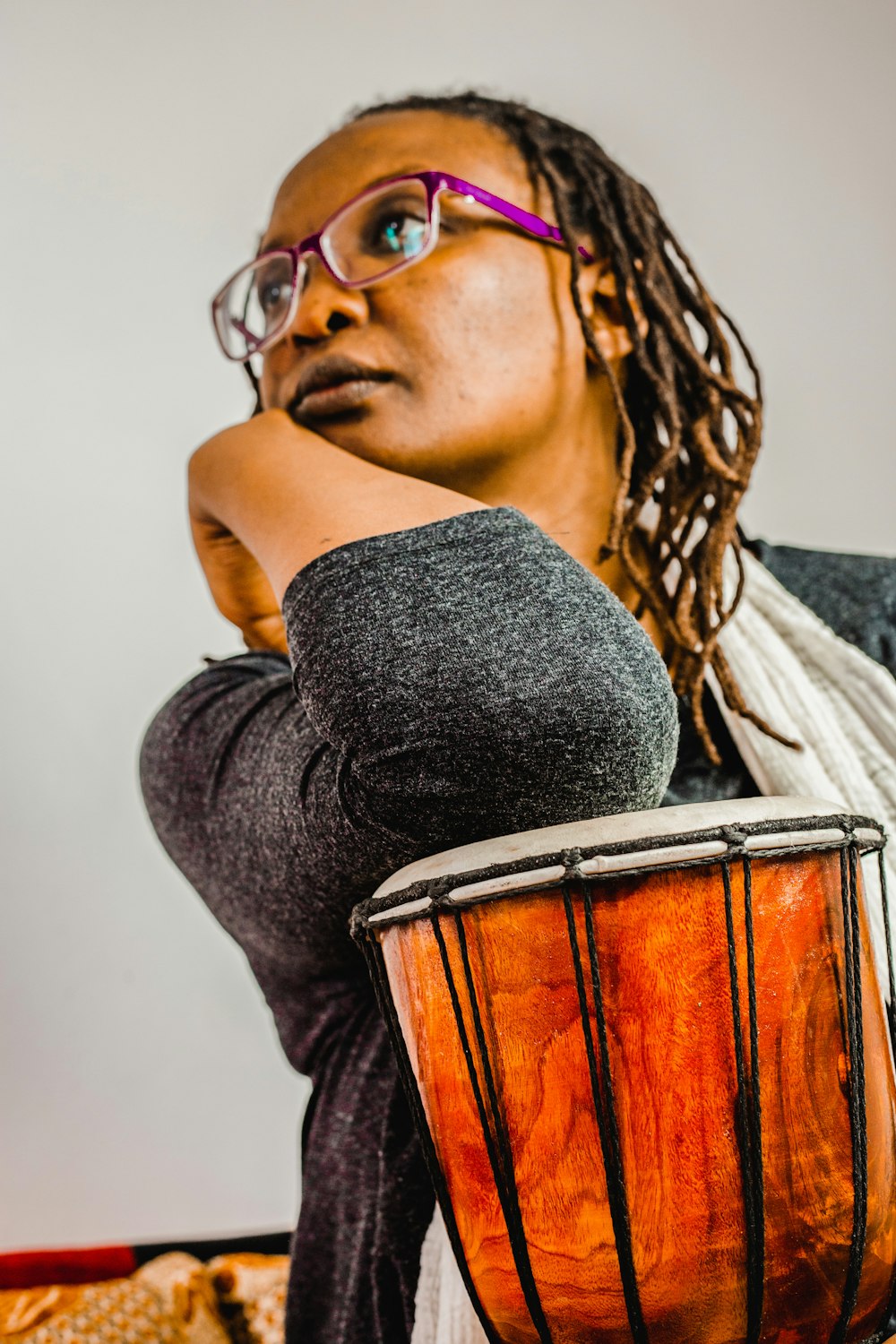 a woman with glasses is holding a drum