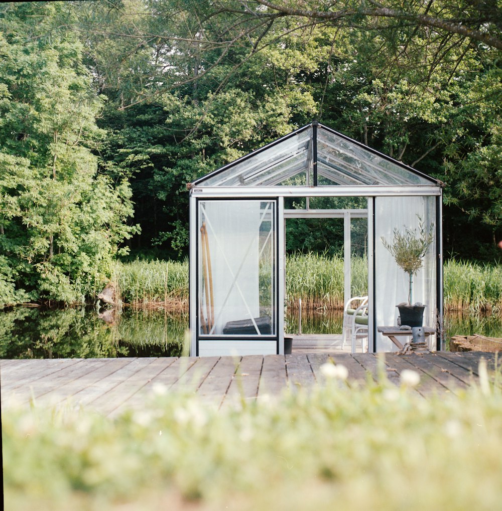 a glass house sitting on top of a wooden deck