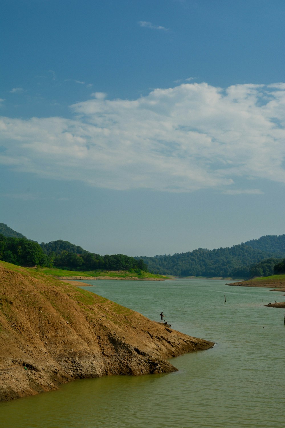 a body of water with a hill in the background