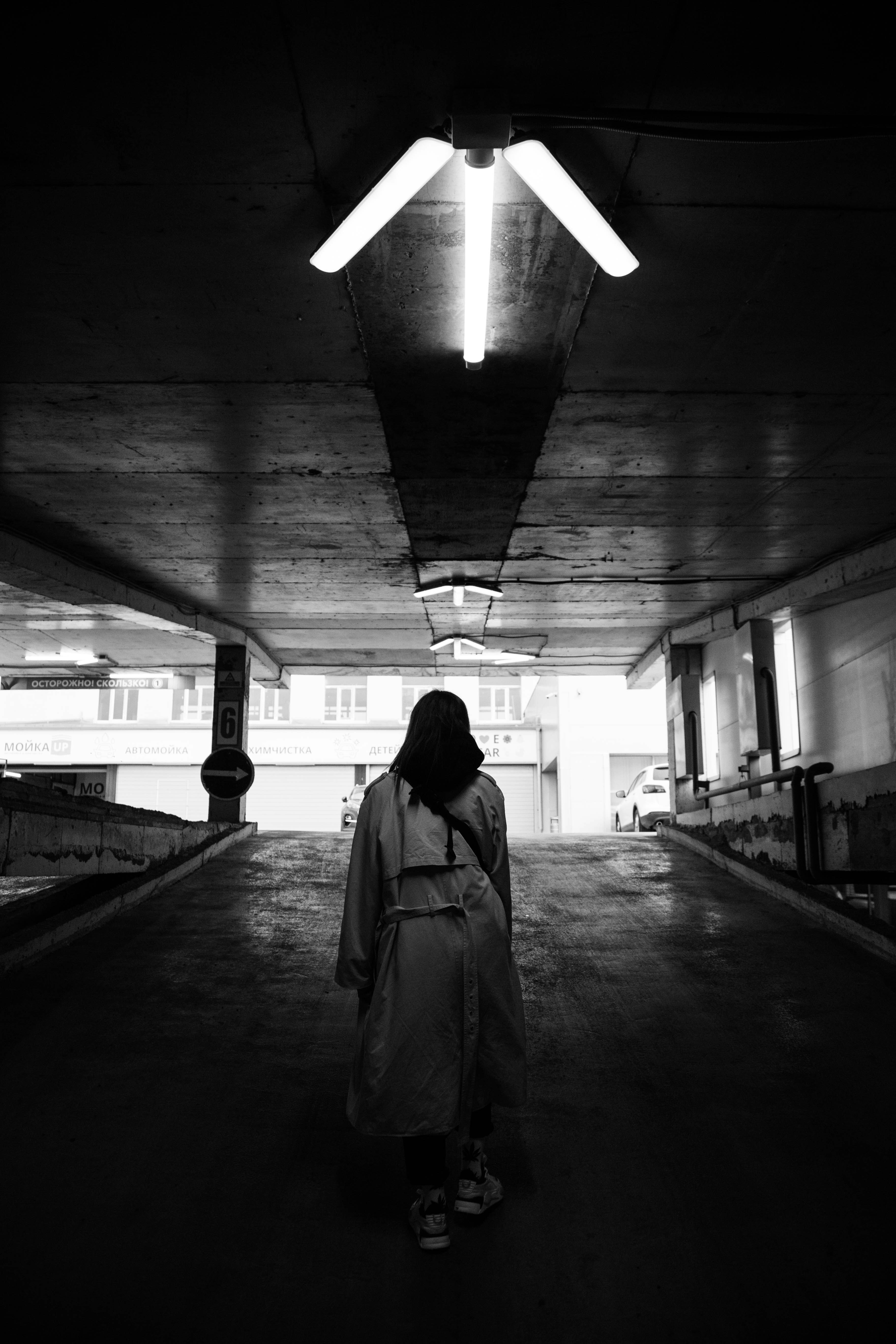 a person standing in a parking garage with a backpack