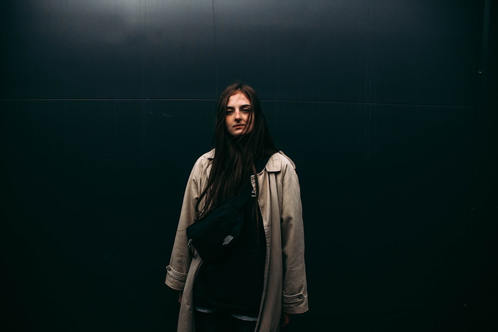 a woman standing in front of a black wall