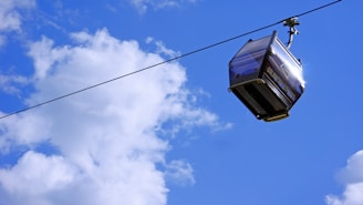 Close-up of a modern cable car pulley system in action against a clear blue sky.