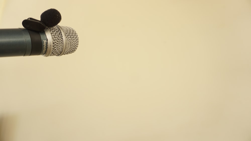 um close up de um microfone com uma parede branca no fundo