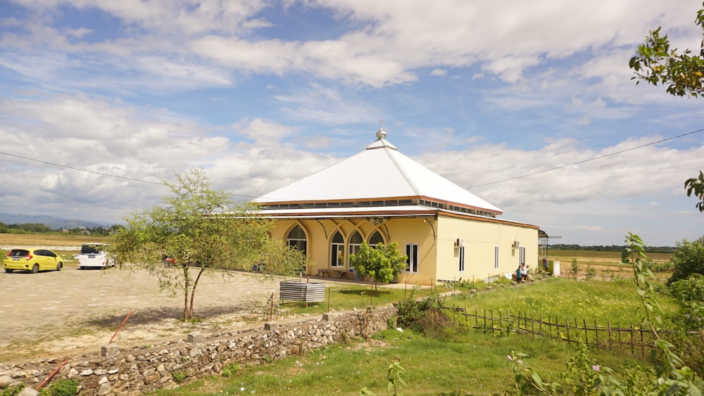 a small yellow building with a white roof