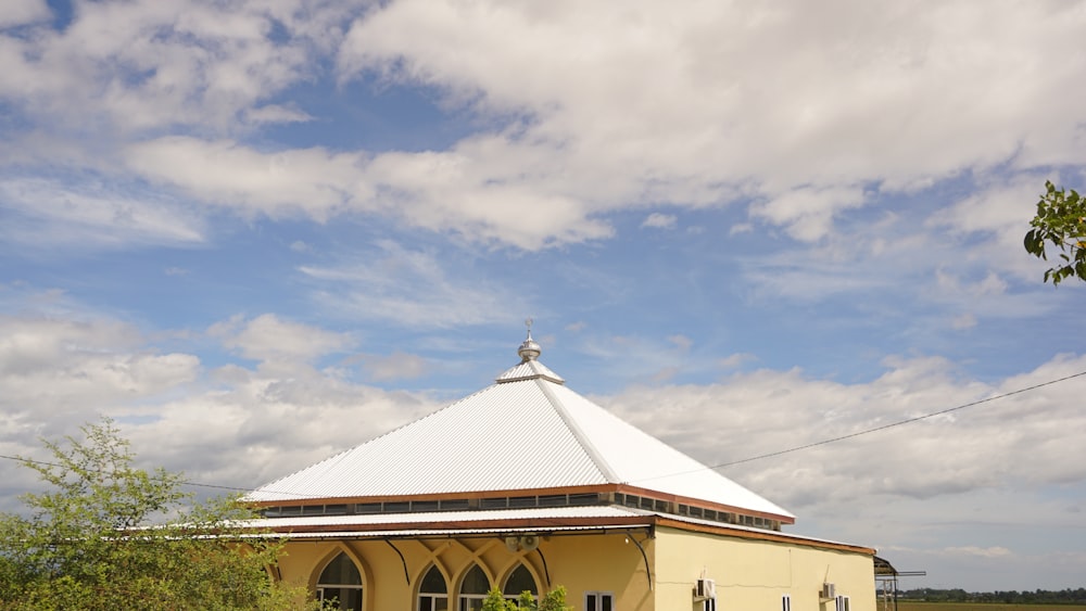 a small yellow building with a white roof