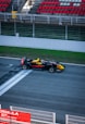 a red and yellow race car driving down a race track