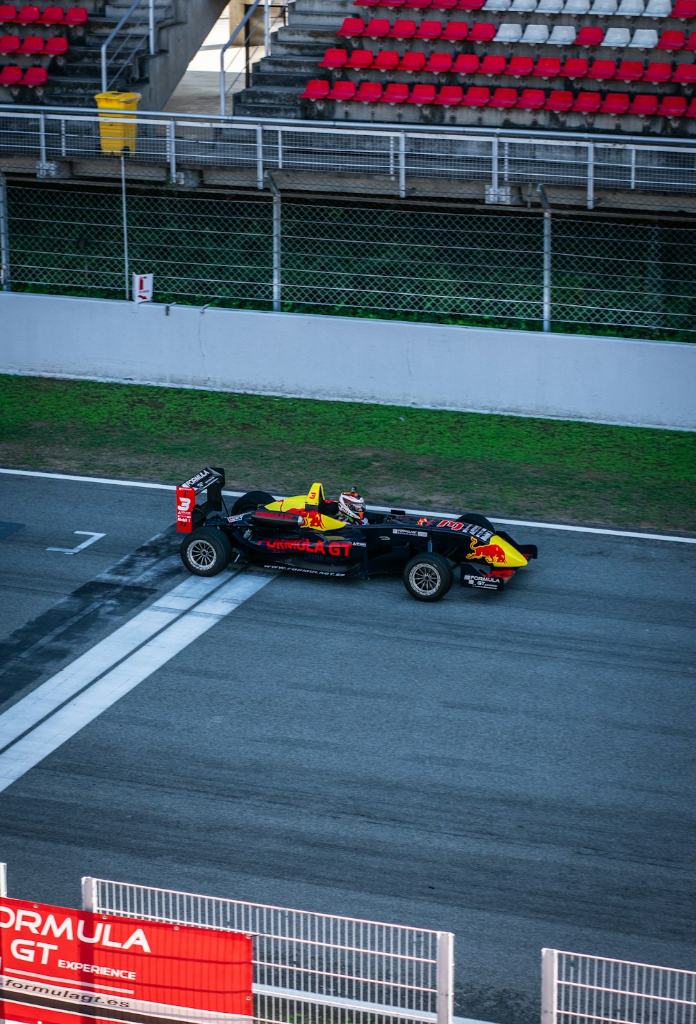 a red and yellow race car driving down a race track