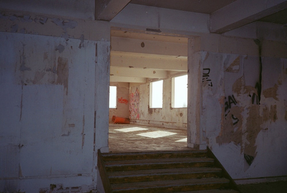 Una habitación vacía con escaleras y graffiti en las paredes
