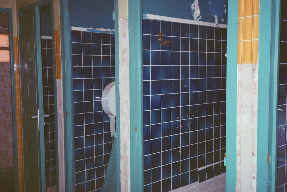 a bathroom with blue tiled walls and a white toilet