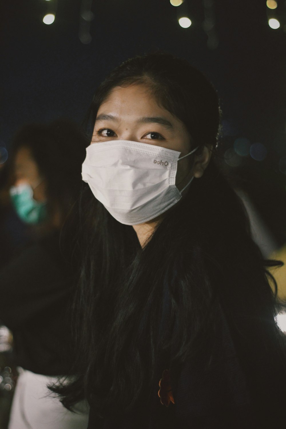 a woman wearing a face mask at night