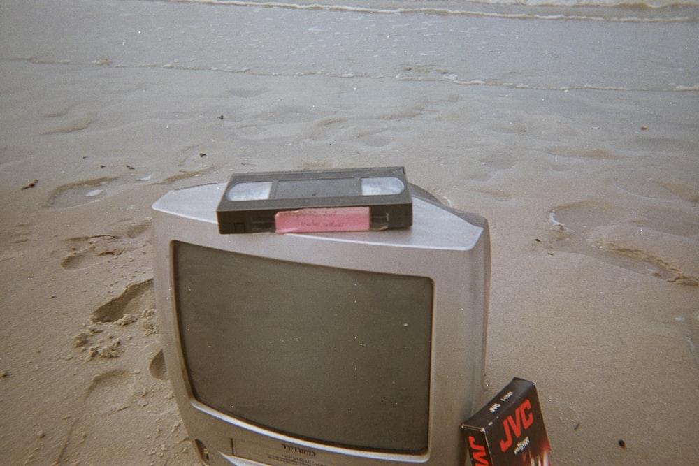a tv sitting on top of a sandy beach