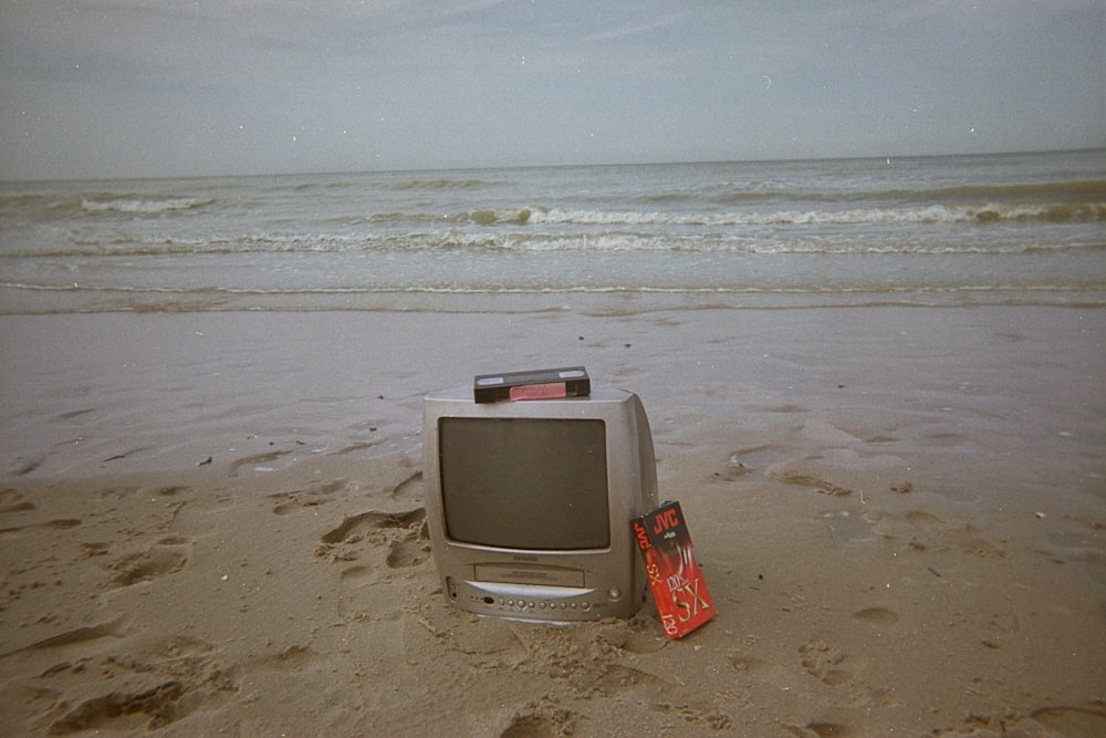 a tv sitting on top of a sandy beach