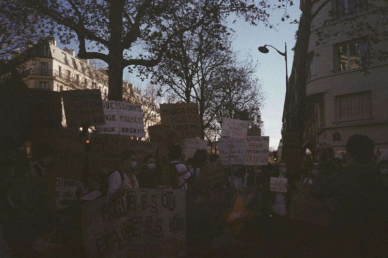 Protesters holding placards and signs during a street demonstration at dusk