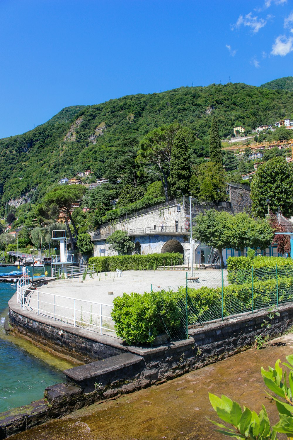 a large body of water next to a lush green hillside