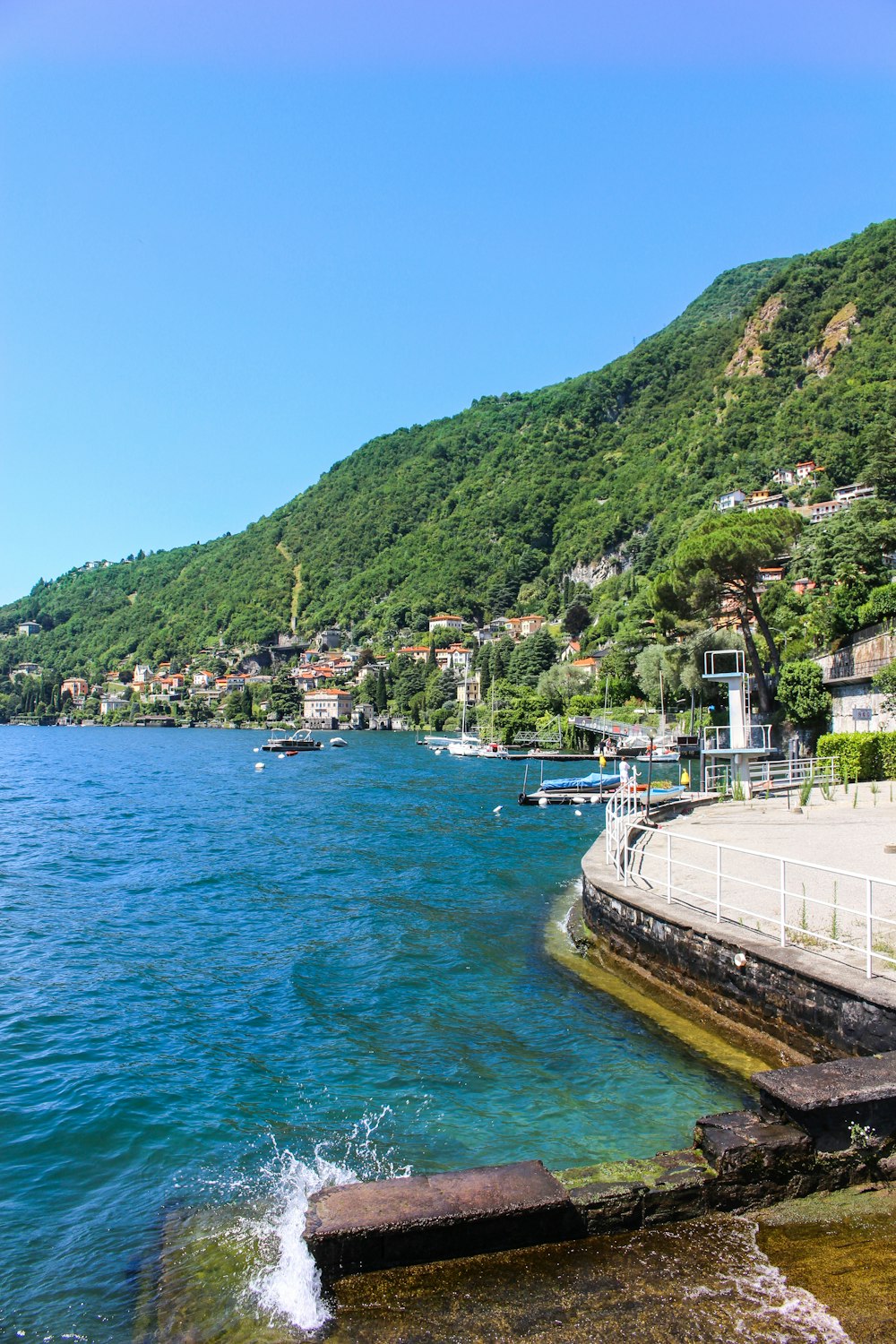 a body of water surrounded by a lush green hillside