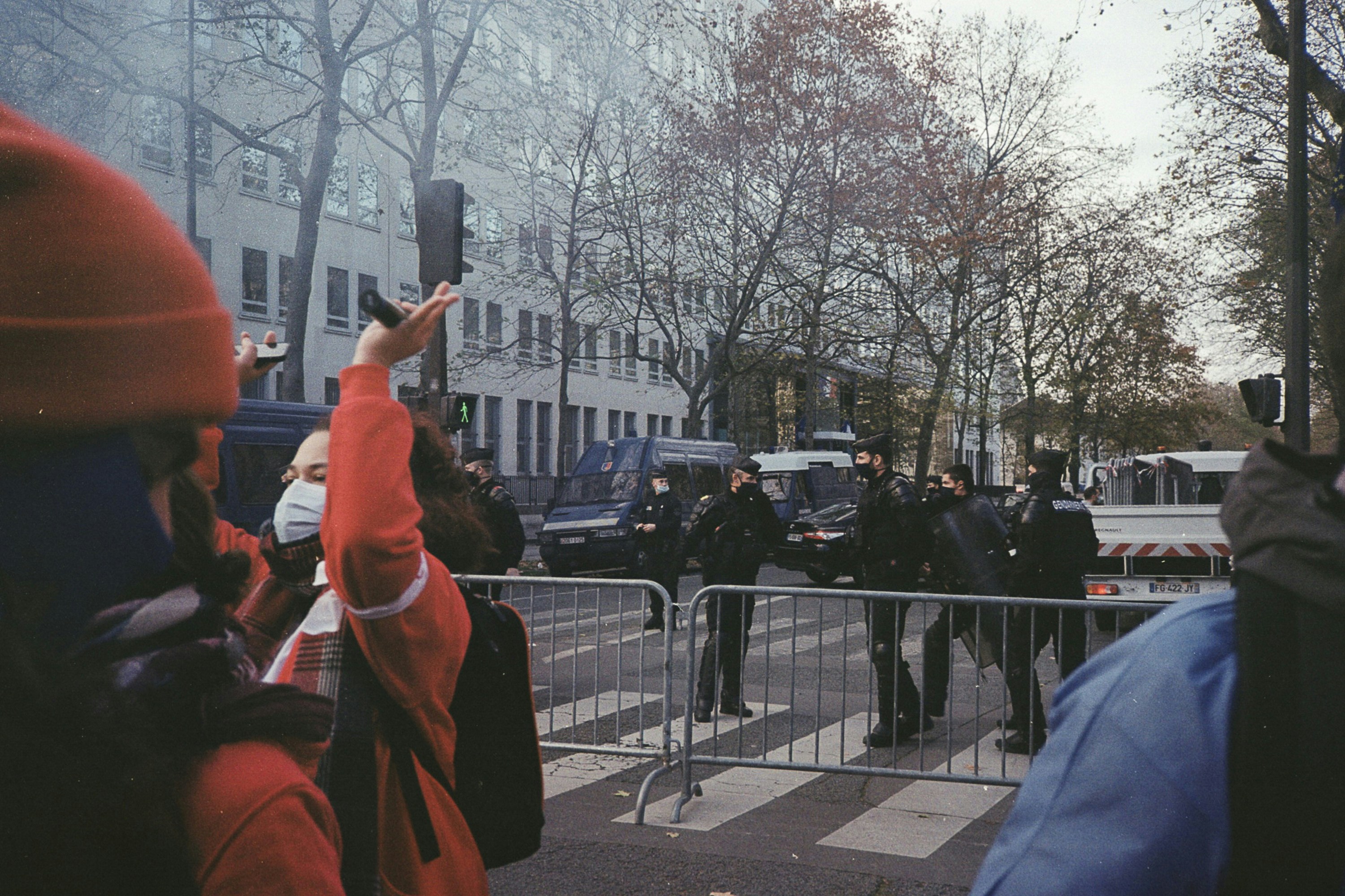 a group of people standing on a street next to a barricade
