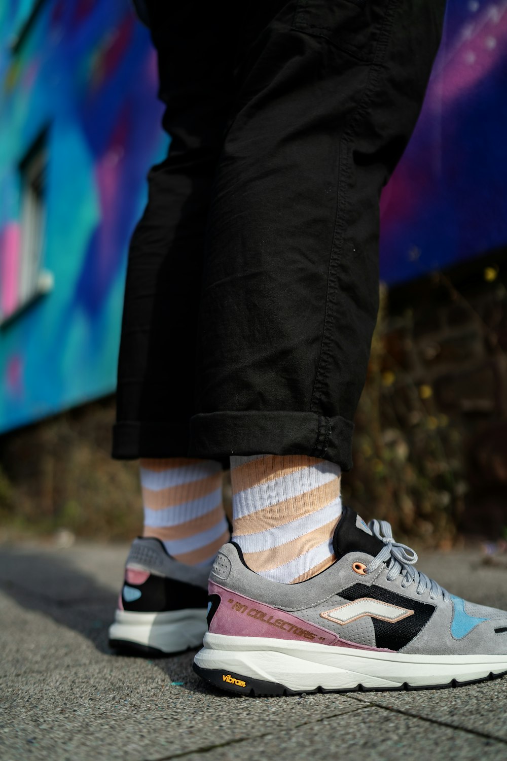 a person standing on a sidewalk with a pair of shoes