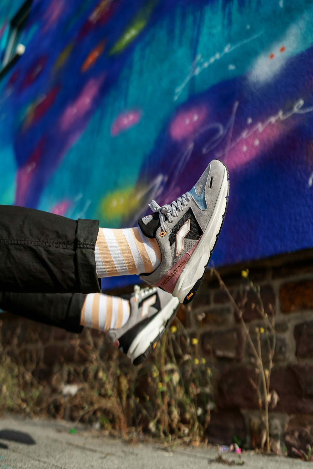 a person in striped socks and black pants jumping in the air