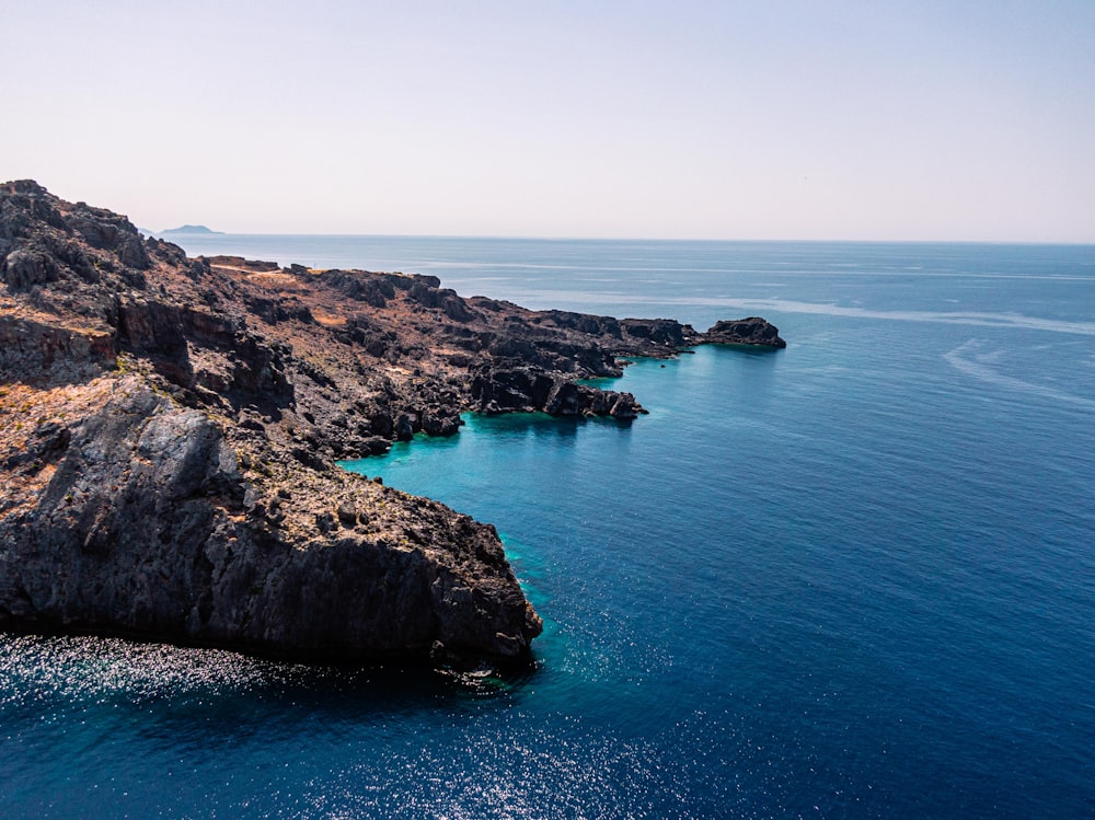 a large body of water next to a rocky shore