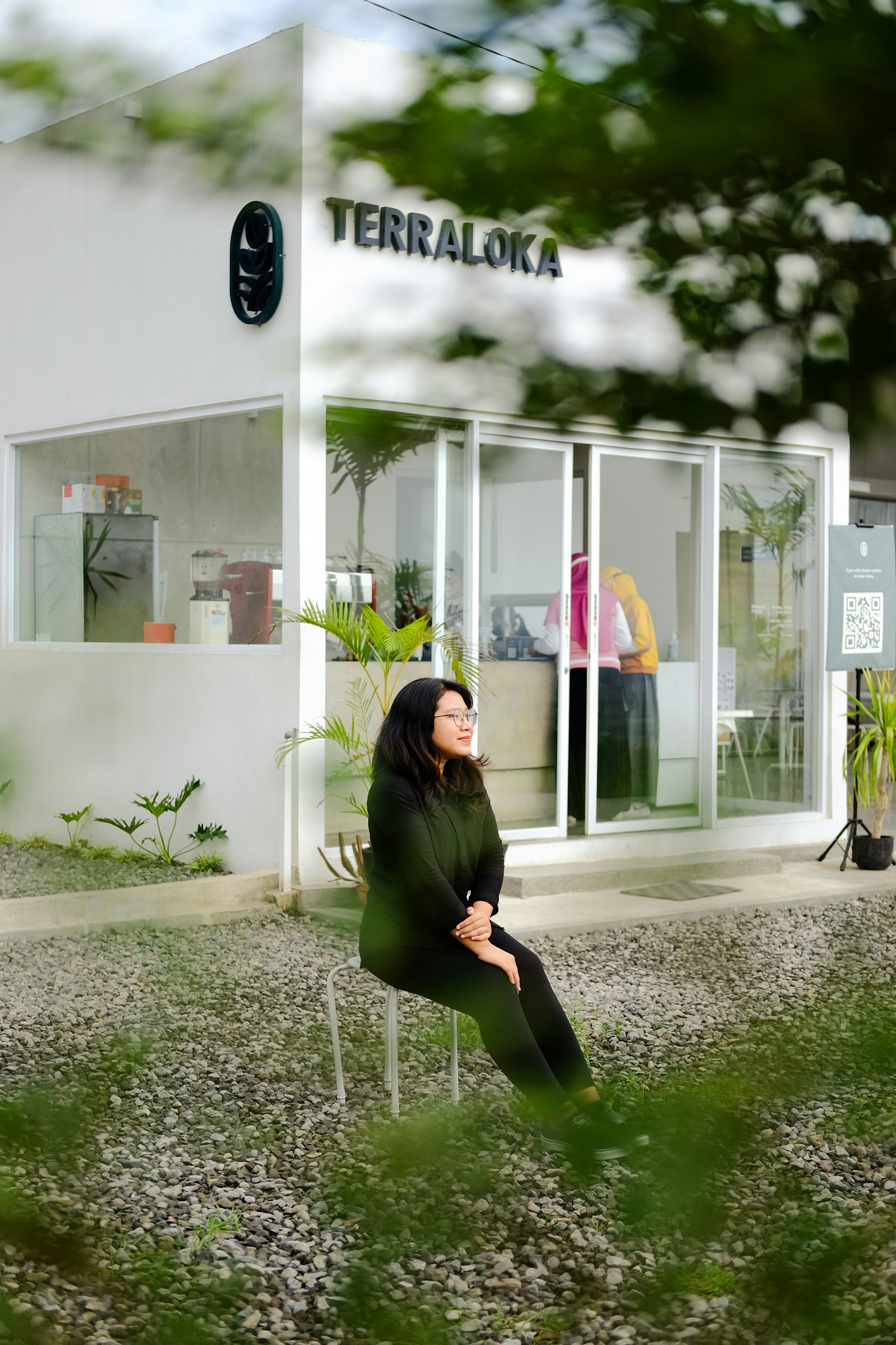 uma mulher sentada em uma cadeira na frente de um edifício