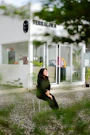 a woman sitting on a chair in front of a building