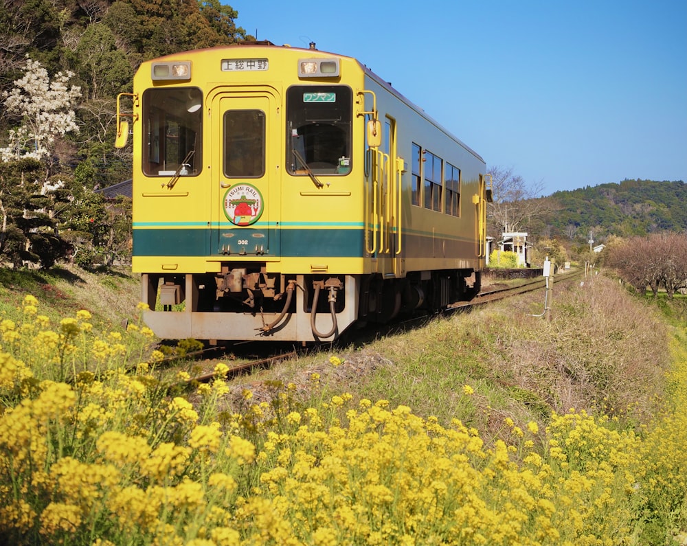 a yellow and green train traveling down train tracks