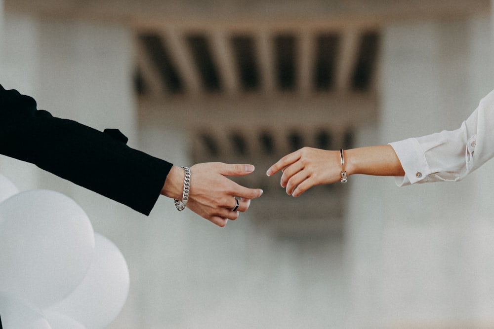 a close up of two people holding hands