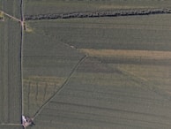 Aerial view of a land parcel being surveyed with visible boundary markers.