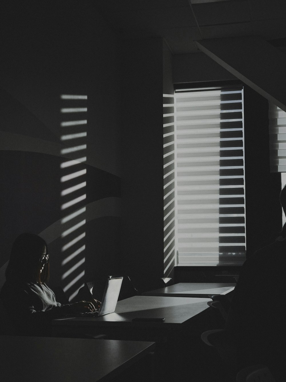 a person sitting at a table with a laptop