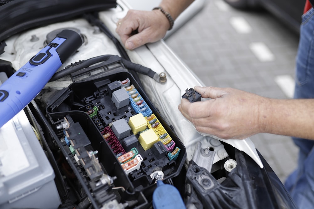 Un uomo sta lavorando sul motore di un'auto