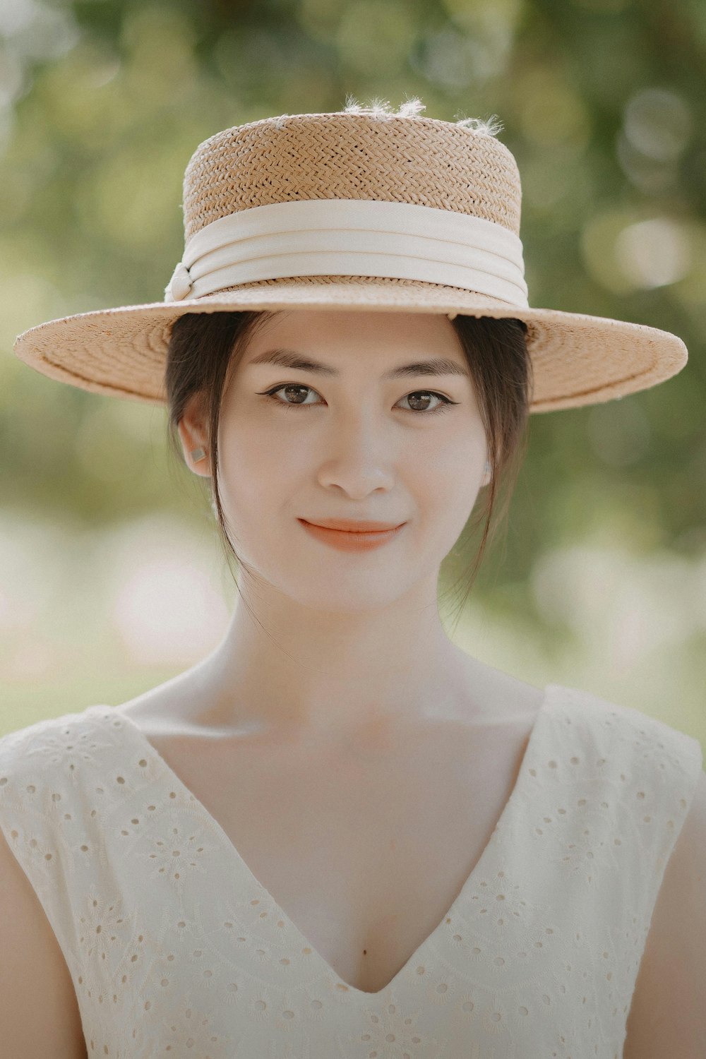 a woman in a white dress and a straw hat