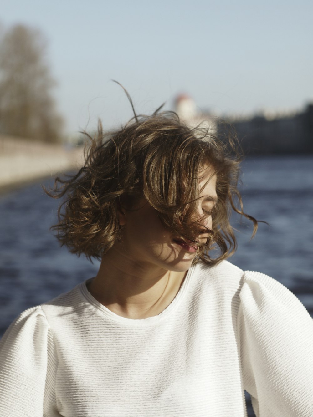 a woman standing next to a body of water