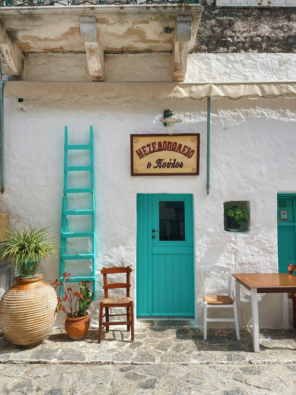 a white building with a blue door and a green door