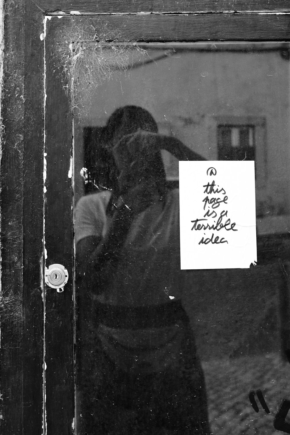 a black and white photo of a person holding a sign