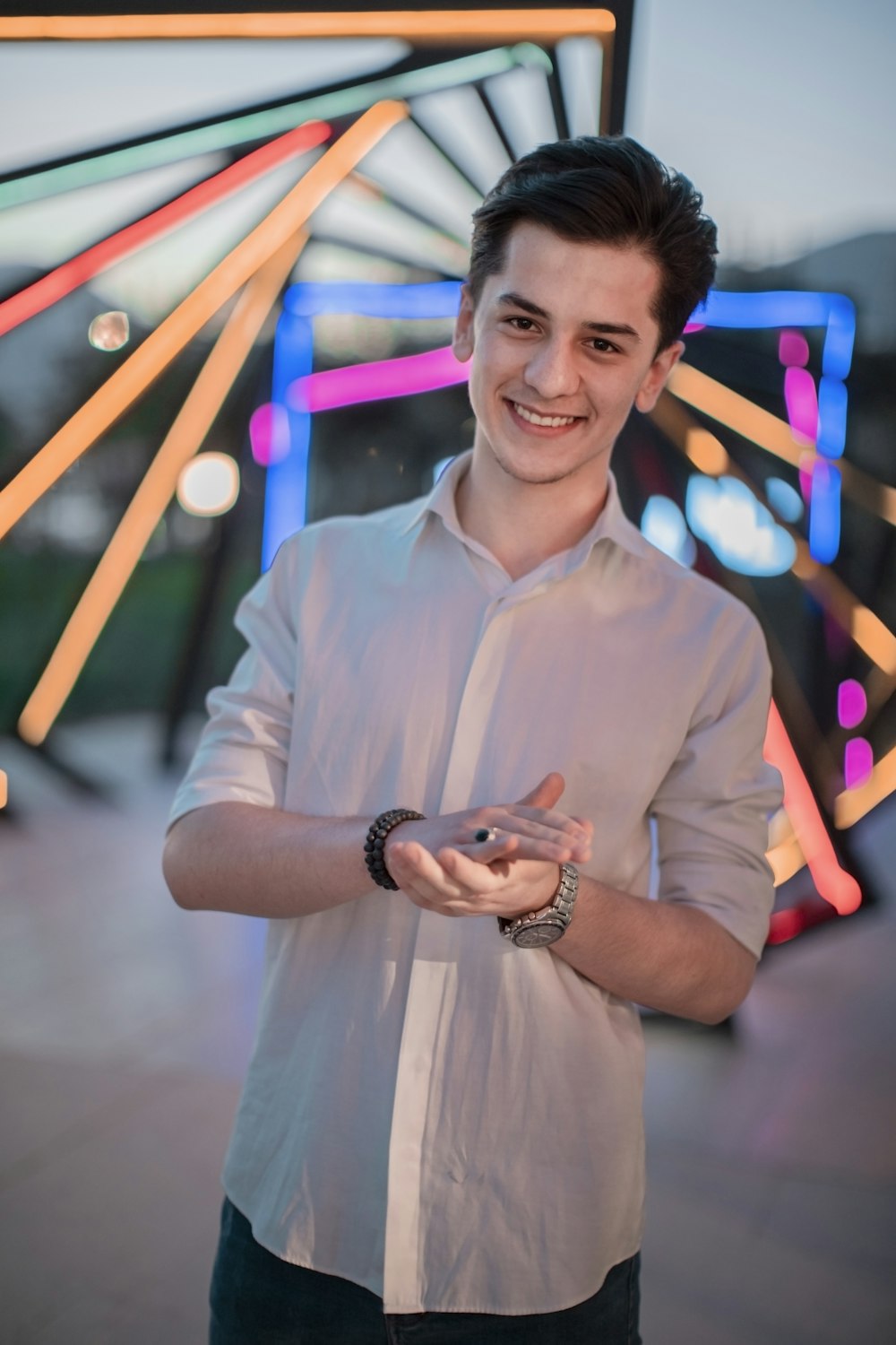 a young man standing in front of a ferris wheel