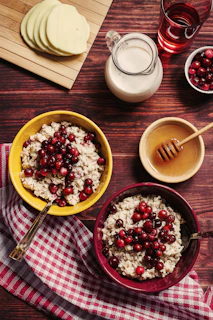 A cozy breakfast spread featuring oatmeal topped with berries, nuts, and a drizzle of honey on a beige linen cloth