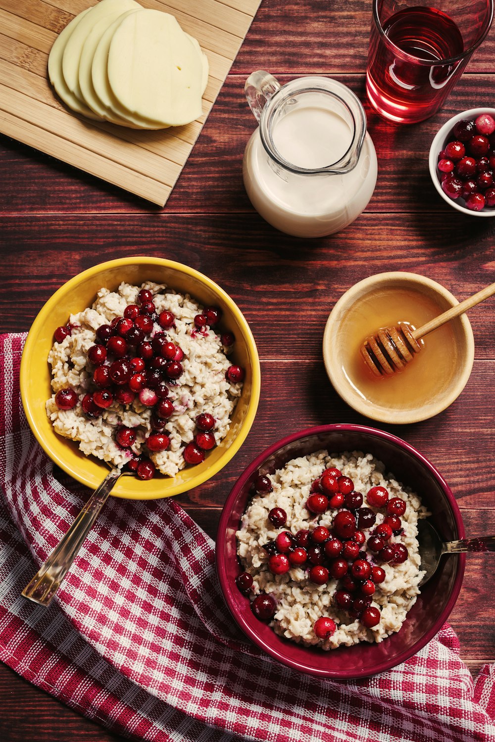 a bowl of oatmeal with cranberries and a glass of milk