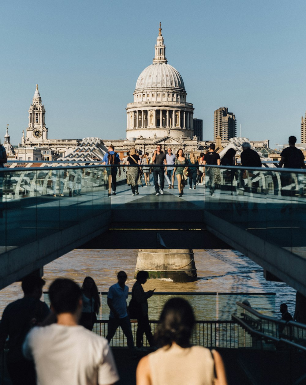 a group of people walking across a bridge