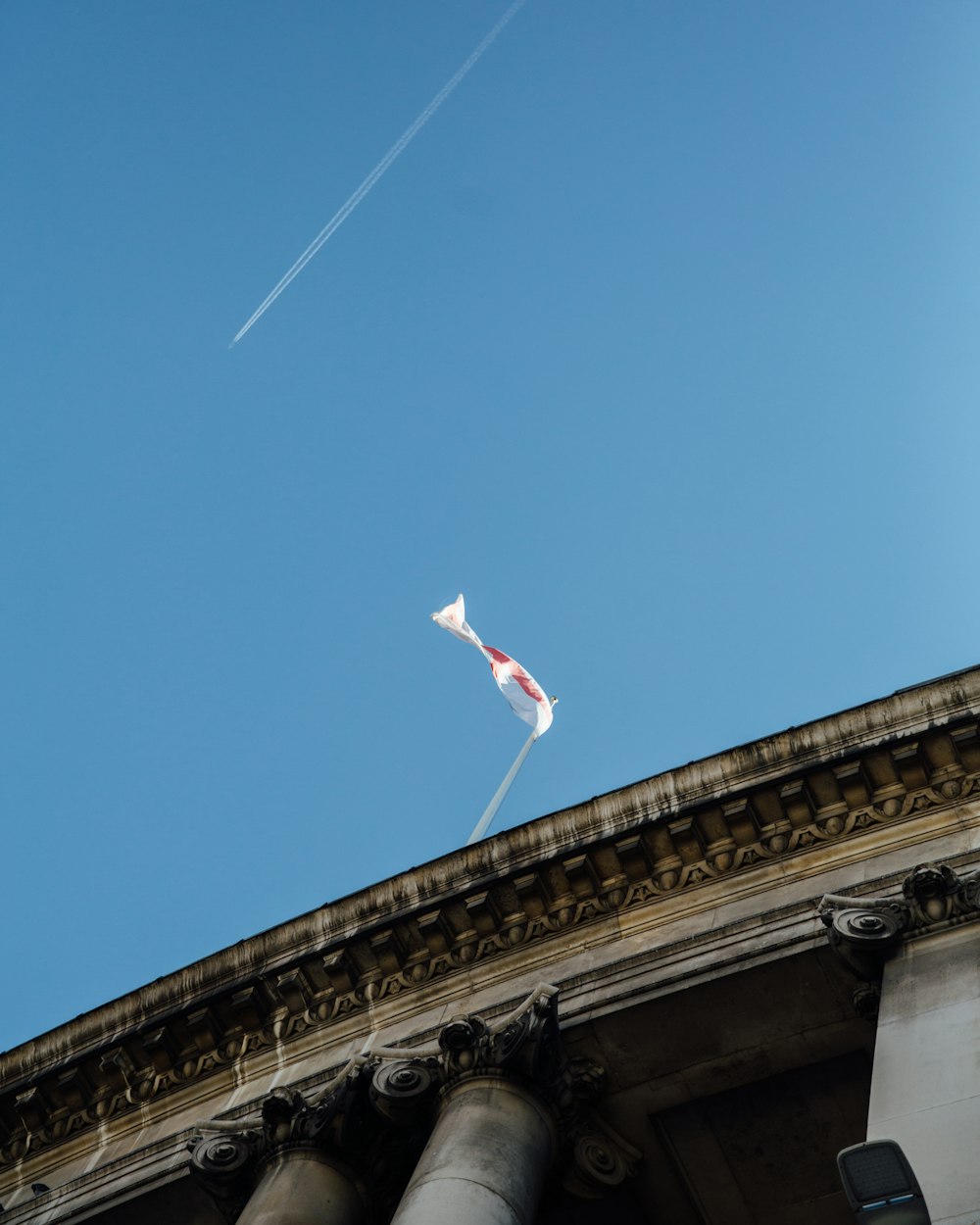 a kite flying high in the sky above a building