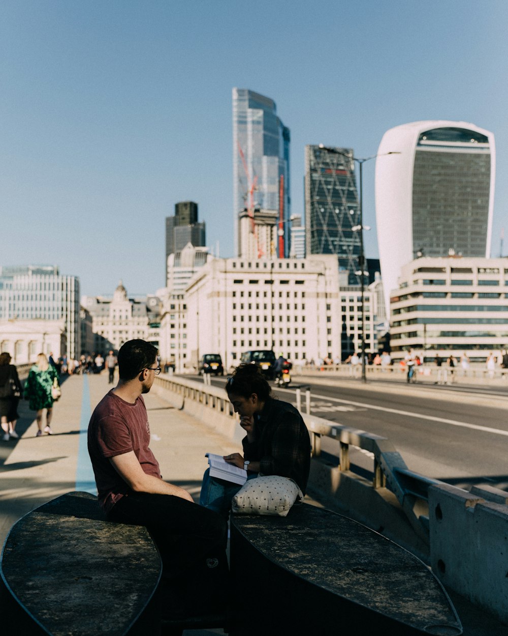 a couple of people sitting on top of a bridge