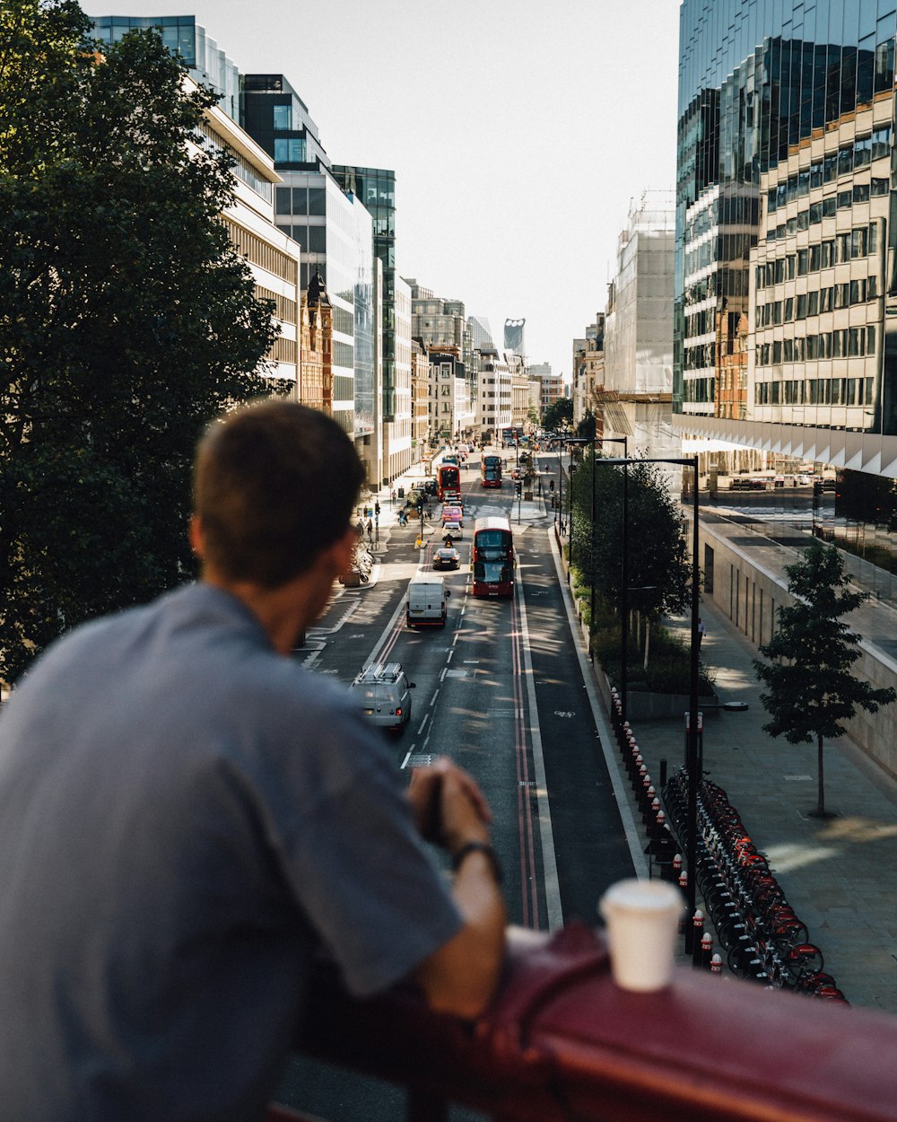 a man standing on a balcony overlooking a city street