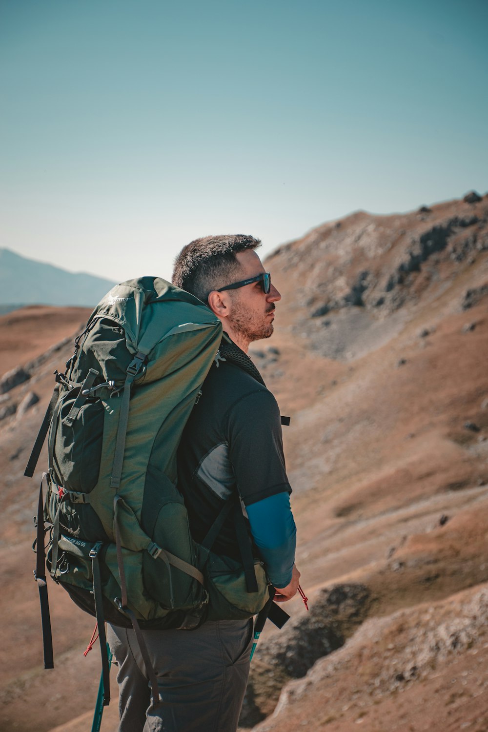 a man with a backpack on top of a mountain
