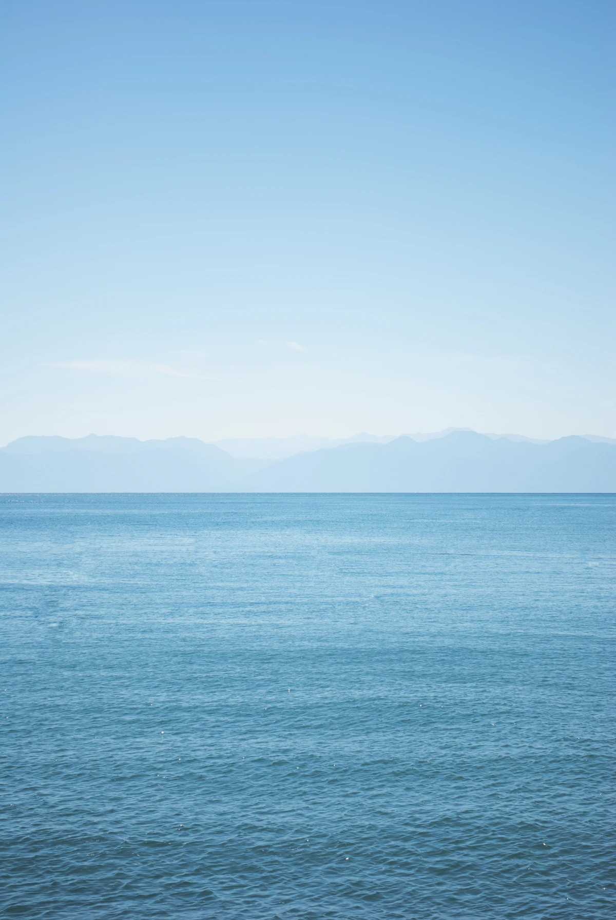 Calm ocean horizon with distant mountains