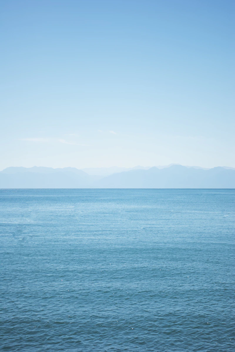 Calm ocean horizon with distant mountains