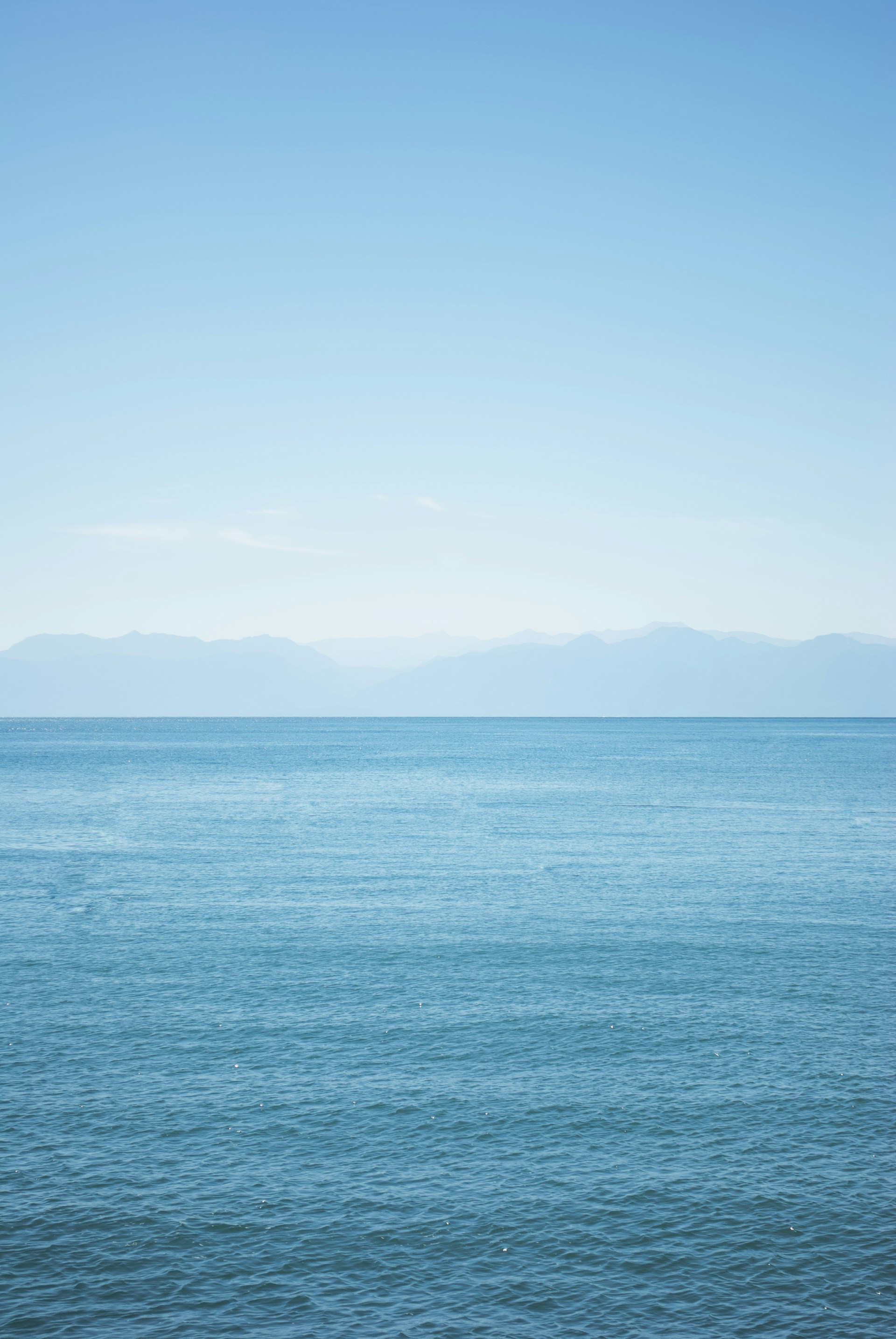 a large body of water sitting under a blue sky