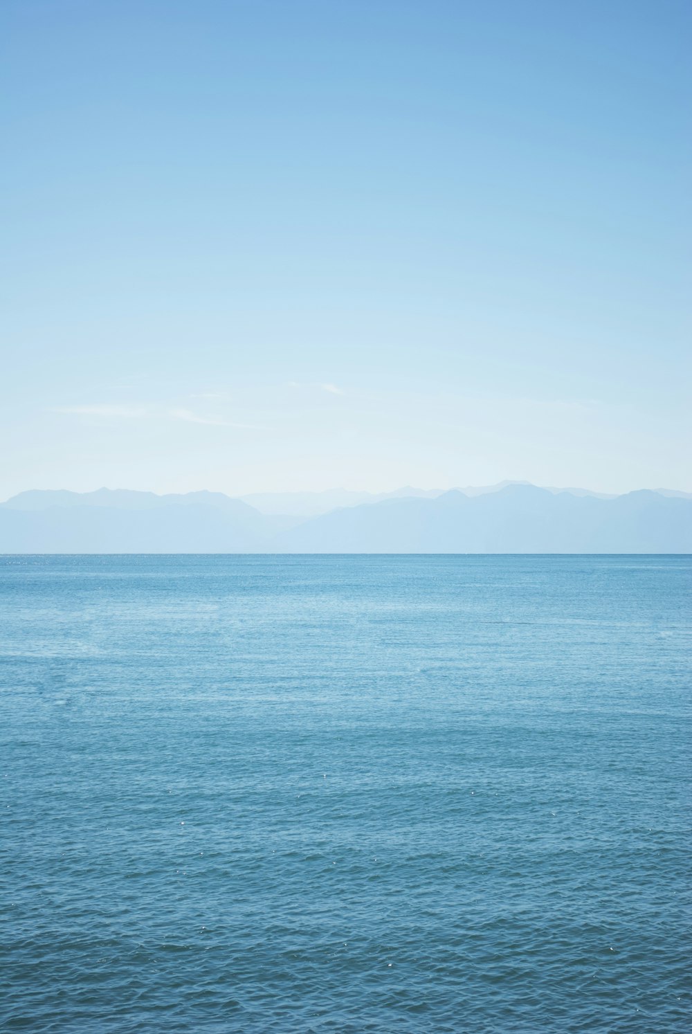 a large body of water sitting under a blue sky